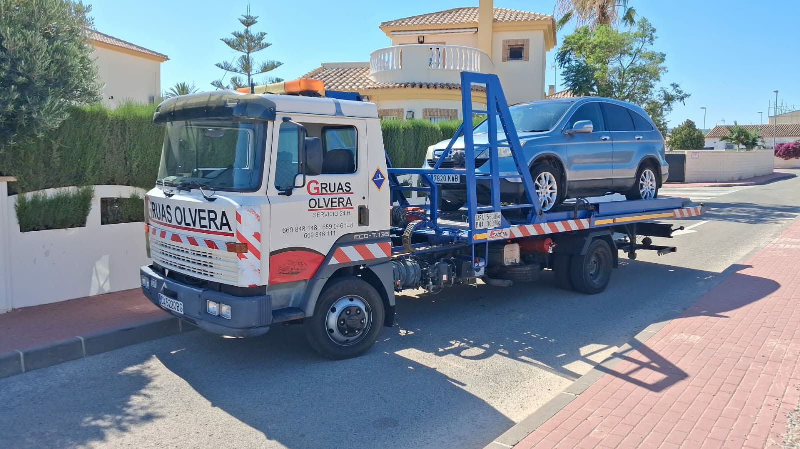 Camión grúa recogiendo un vehículo en una calle de Alicante
